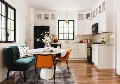 White shaker kitchen with stacked glass cabinets and small dining table