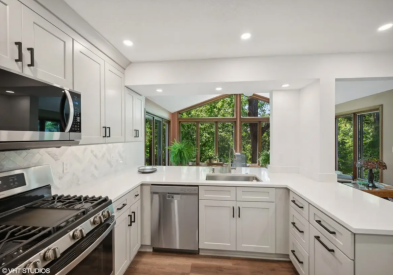 Light gray shaker kitchen design with peninsula and white quartz countertops