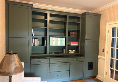 Dark green shaker cabinets in a den for book storage 