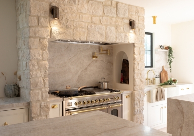 White inset shaker kitchen cabinets on a range wall with built-in Mediterranean stone alcove for the range