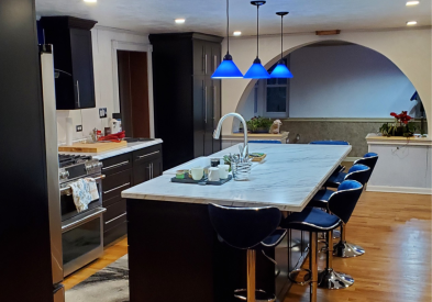 Black shaker kitchen cabinets with white countertops, blue lighting, and blue subway tile backsplash