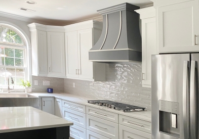 Curved wood kitchen hood in gray finish with steel strapping