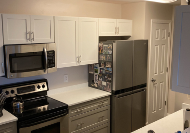 Shaker galley kitchen with white wall cabinets, gray base cabinets, and white quartz countertops