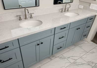 Beautiful bathroom vanity with drawers in light gray and blue undertone paint finish and black cabinet hardware