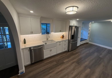 One-wall white shaker kitchen design with stainless steel appliances and white stone countertops