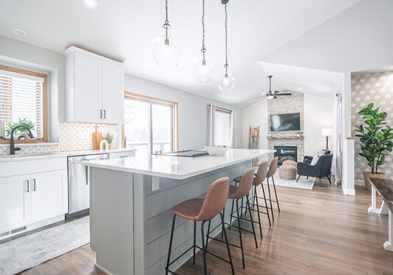 White and light gray shaker kitchen cabinets with dark cabinet hardware, light wood accents, and modern decor