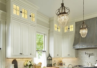 elegant kitchen with painted white cabinets, custom glass door ceiling height cabinets, crystal chandelier and custom metal range hood