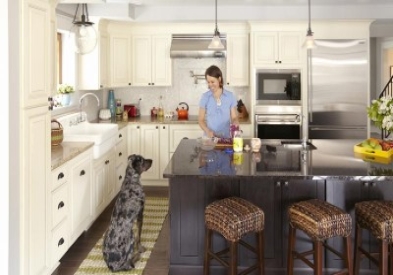 woman cooking at center island smiles at large dog waiting for treat