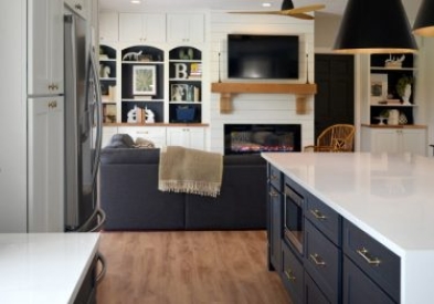 Black shaker kitchen cabinets with kitchen island and white quartz waterfall countertops