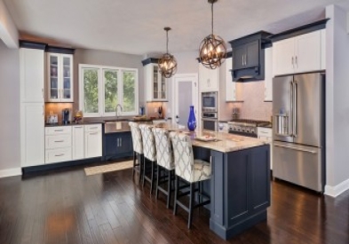 Beautifully designed open floor plan kitchen features painted shaker style cabinetry by CliqStudios. Shown Dayton shaker cabinet style in painted White finish and paired with Dayton in painted black finish.