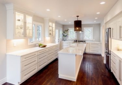 Large U-shaped white shaker kitchen cabinet with drawer bases, glass wall cabinets and a long kitchen island 