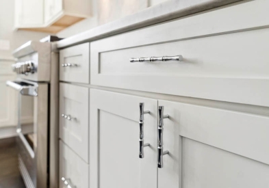 White shaker kitchen base cabinet close-up with brushed nickel cabinet pulls