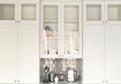 built in buffet made of white shaker cabinets with glass doors, countertop cabinets and coffee station