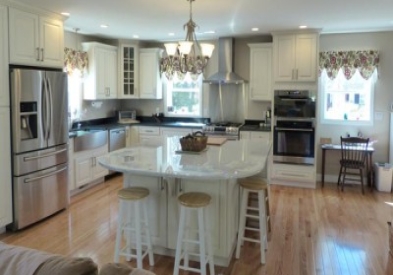 open kitchen design with traditional cabinets has chandelier over the large island, tall glass display cabinet in the corner, stepped levels