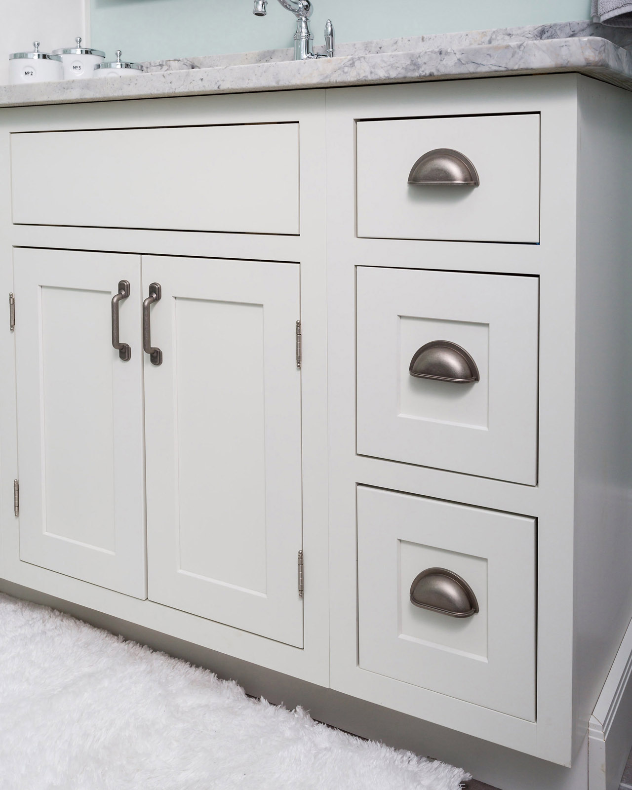 CliqStudios bath cabinets shown in Shaker White door style and finish