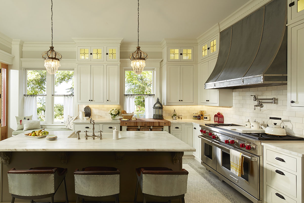 G-shaped kitchen layout featuring cream cabinetry and black cabinet hardware