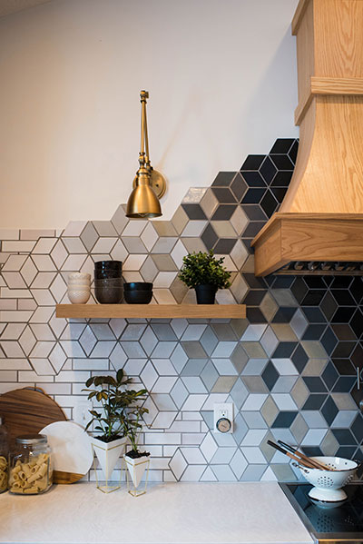 Transforming patterned backsplash, wood range hood and open shelf with lamp.