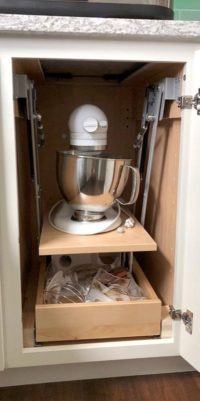 Base Cabinet for Stand Mixer storage, containing a standing mixer on the top shelf and mixing accessories on the bottom shelf.