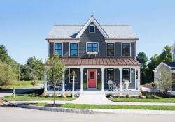 Outside of a blue and white two story house with front porch and red front door