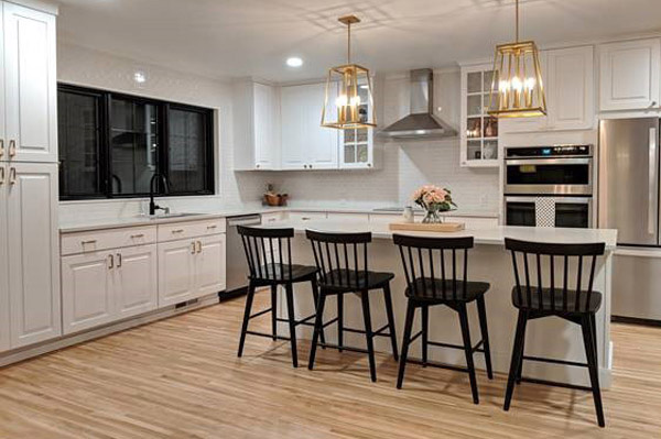 modern white and black kitchen with island seating, glass-front cabinets surround the range hood and large black window above the sink