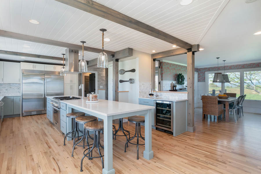 Gray kitchen island with space for seating and stainless steel stove