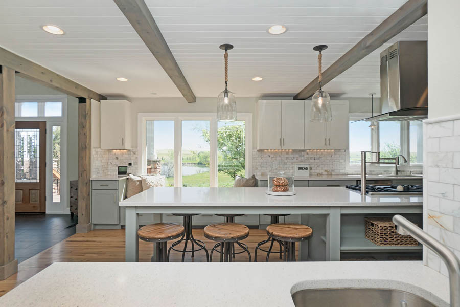 gray and white farmhouse kitchen with exposed beams and wood.