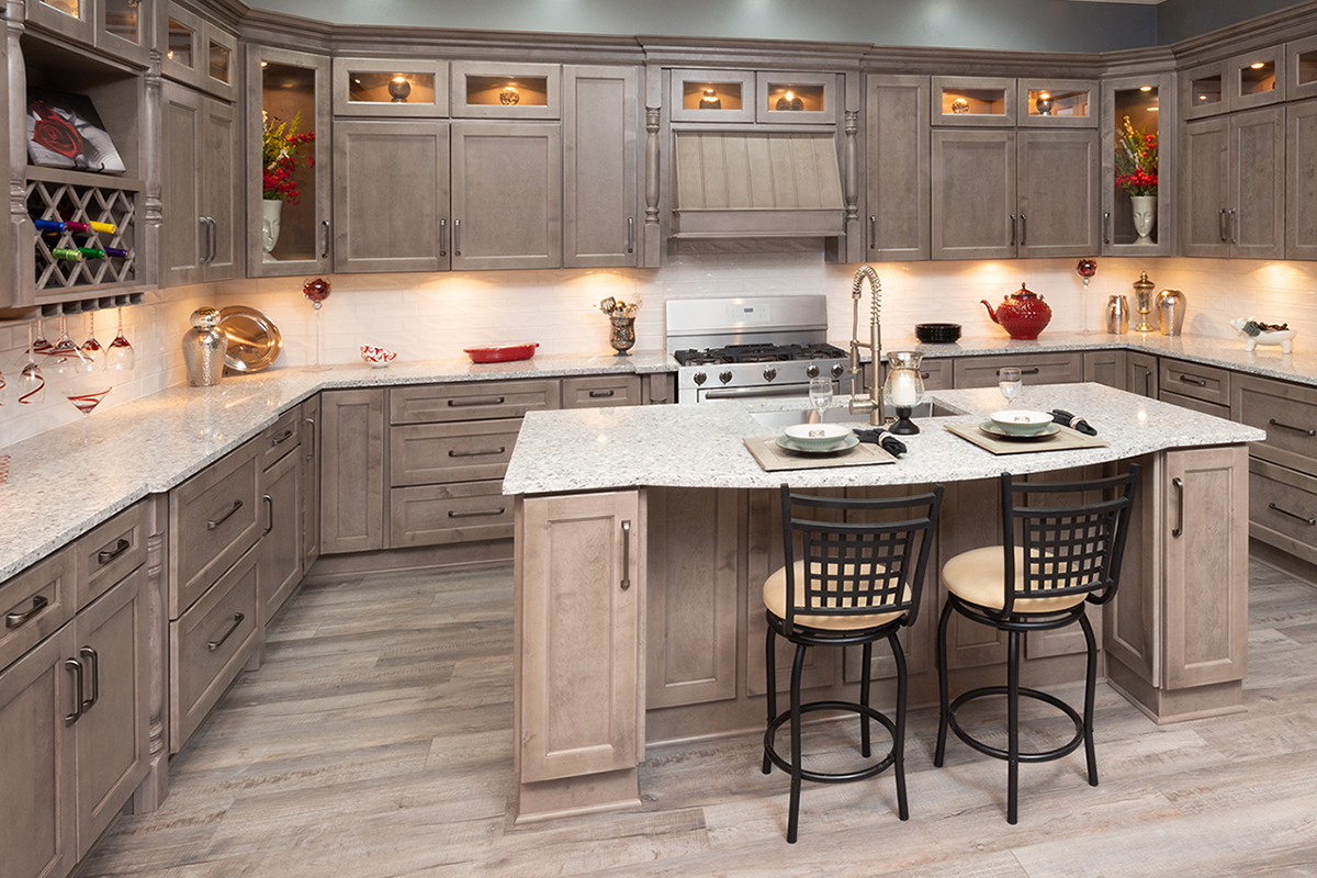 Light brown stained kitchen cabinets with an island and white countertops