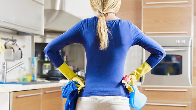 Woman surveying the kitchen while cleaning