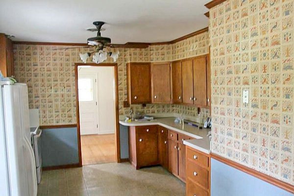 kitchen with blue wallpaper, golden oak cabinets and linoleum flooring