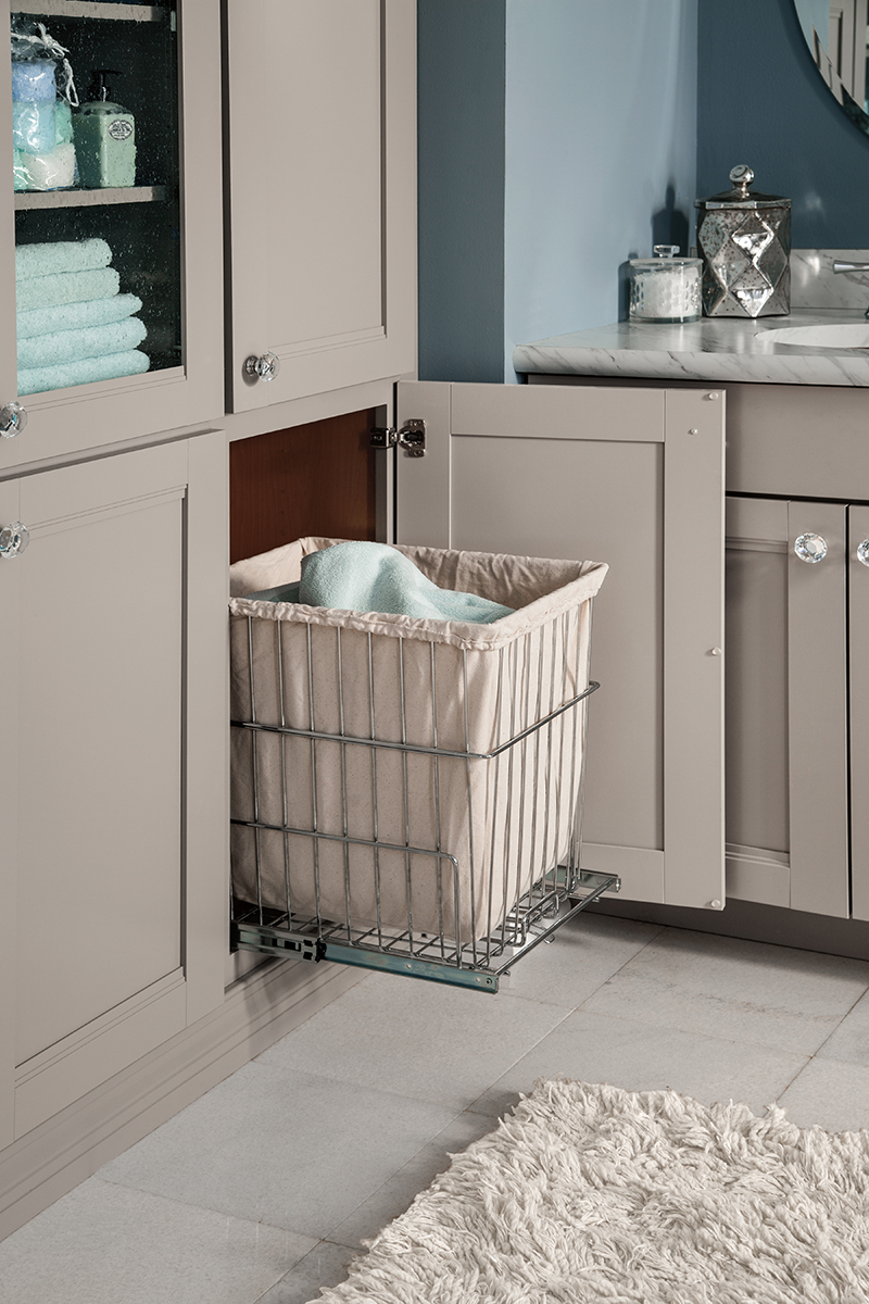 This image is of gray pull-our cabinet organizers in a bathroom design used to store laundry.