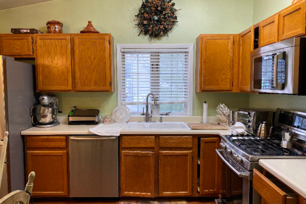 Before photo with golden oak cabinets and light green walls