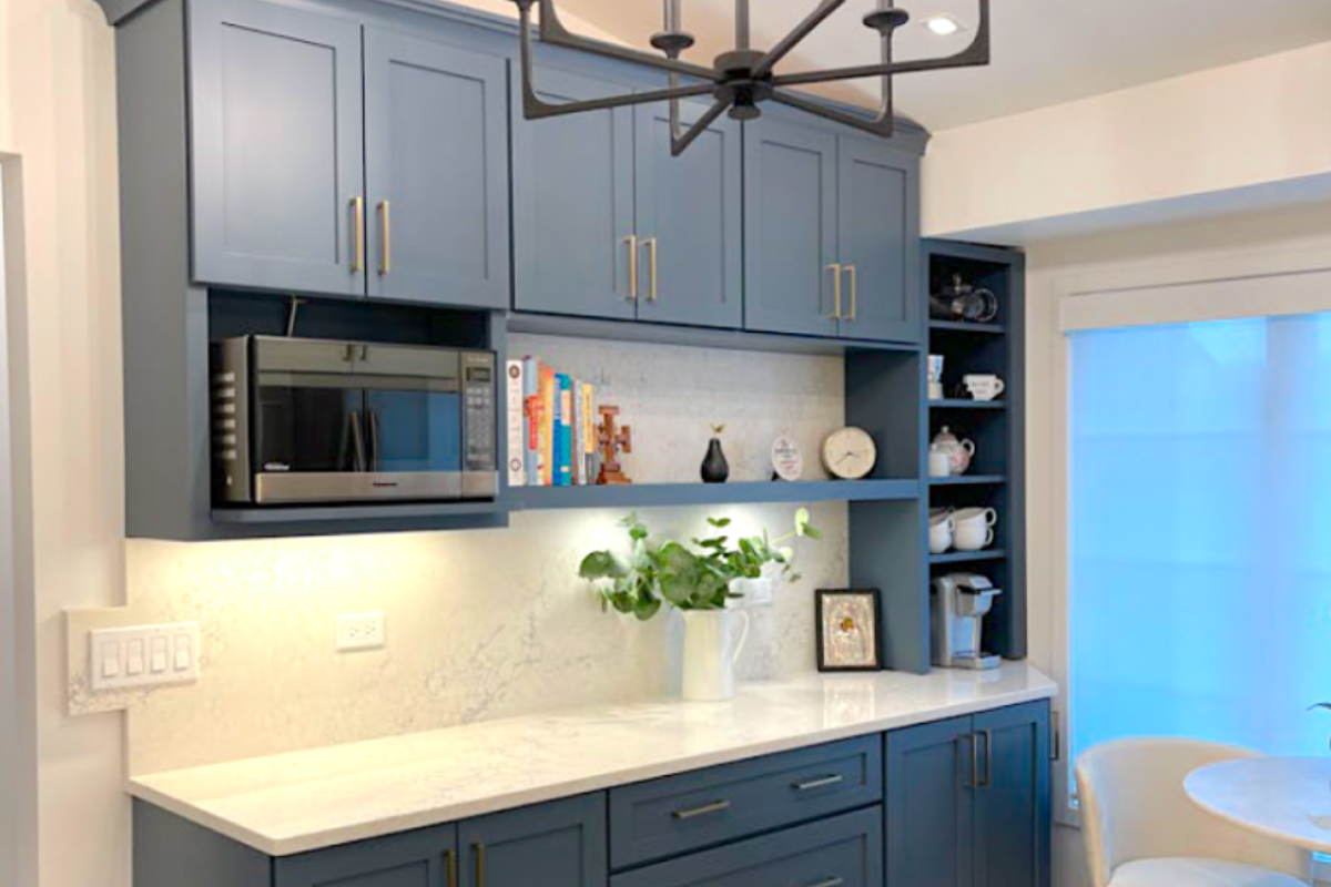 Medium blue buffet kitchen cabinets with light cream stone countertops
