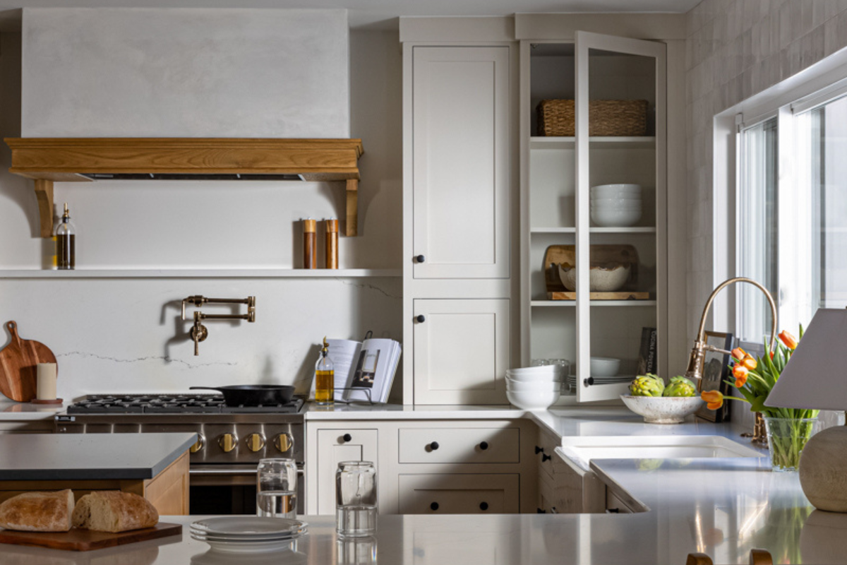 Light cream inset kitchen cabinet design with medium wood accents and plaster kitchen hood
