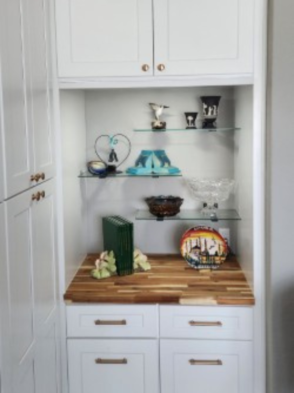 White shaker display kitchen cabinets with wood butcher block countertops and gold cabinet hardware