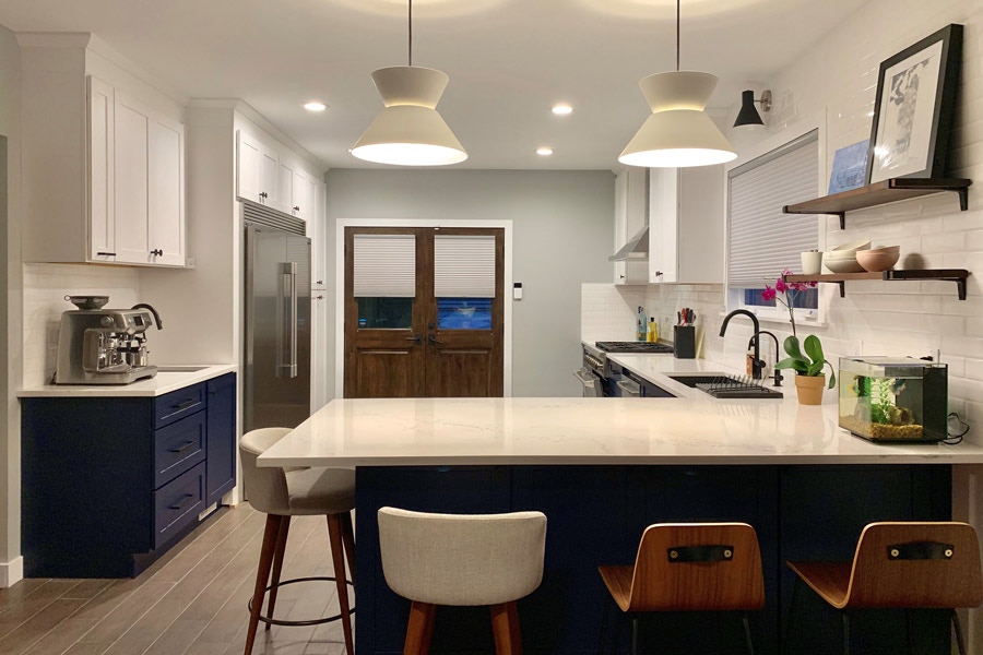 open kitchen with l-shaped peninsula, blue base cabinets and white upper cabinets