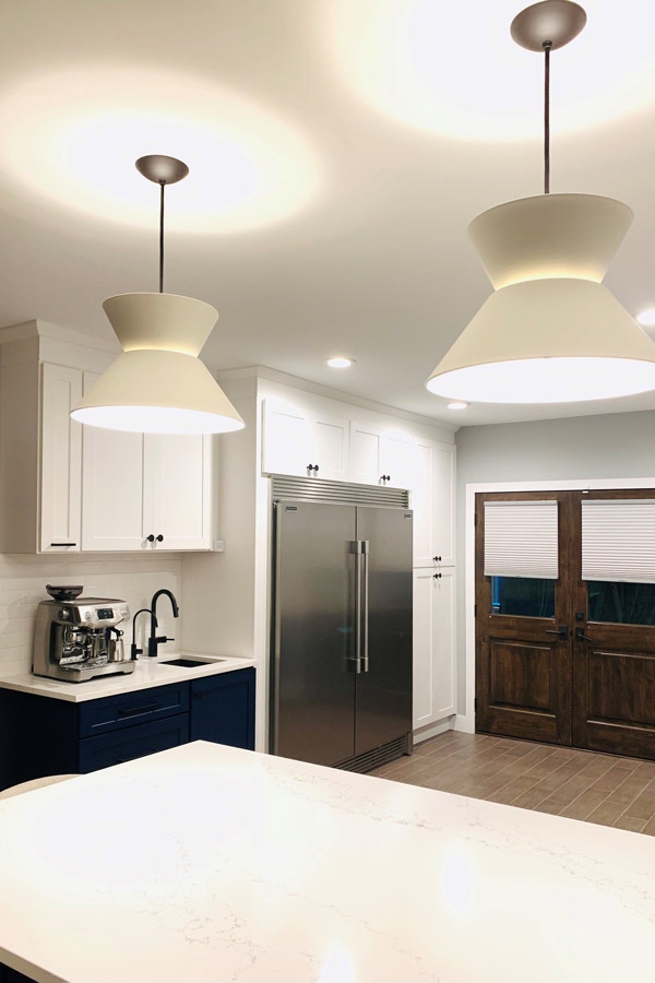 open kitchen with l-shaped peninsula, blue base cabinets and white upper cabinets