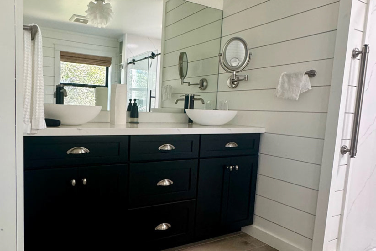 Double-sink vanity in black shaker door style with drawers in the center and white vessel sinks