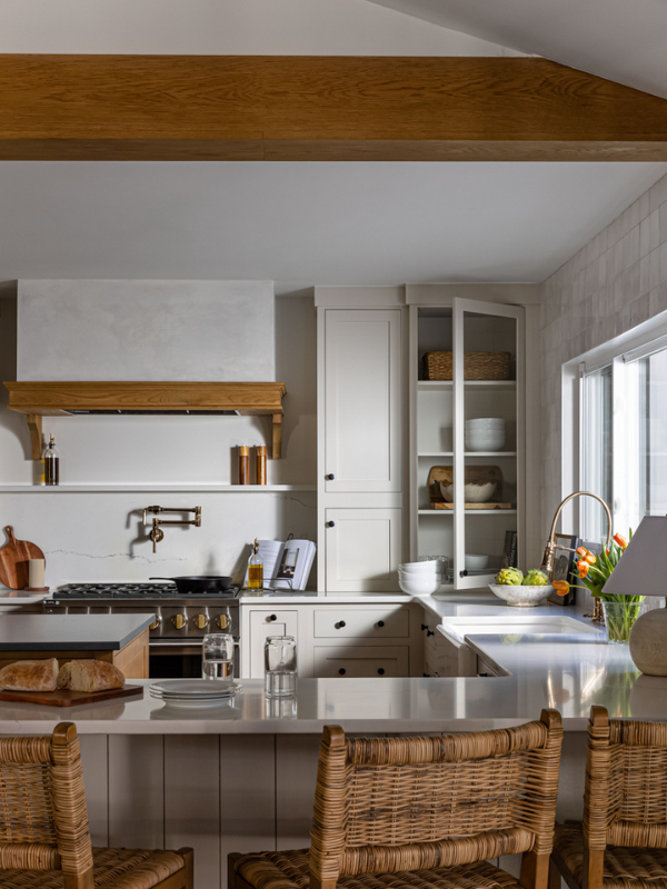 European kitchen design with cream inset cabinets and wood accents with a plaster kitchen hood