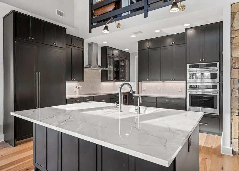 Rustic, open kitchen with black shaker cabinets and a large island