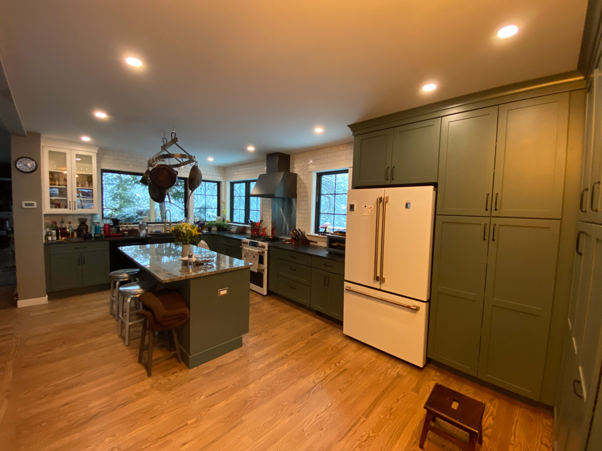 Large dark green kitchen remodel with white and gold appliances and white subway tile backsplash