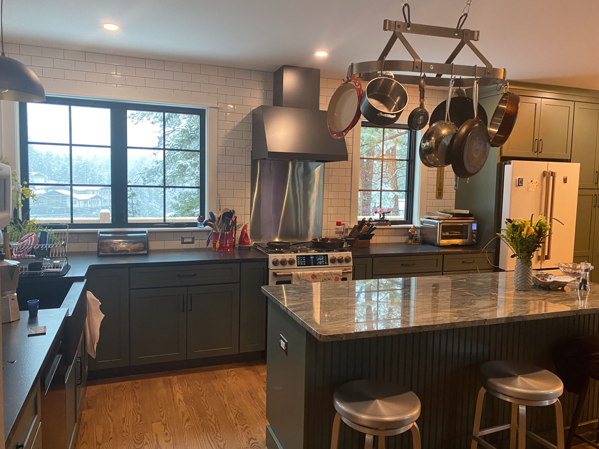 Large dark green kitchen remodel with white and gold appliances and white subway tile backsplash