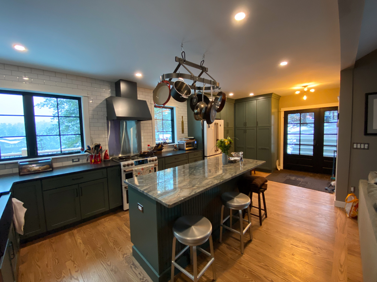 Large dark green kitchen remodel with white and gold appliances and white subway tile backsplash