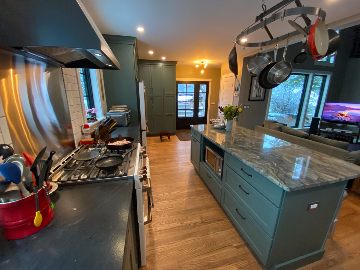 Large dark green kitchen remodel with white and gold appliances and white subway tile backsplash