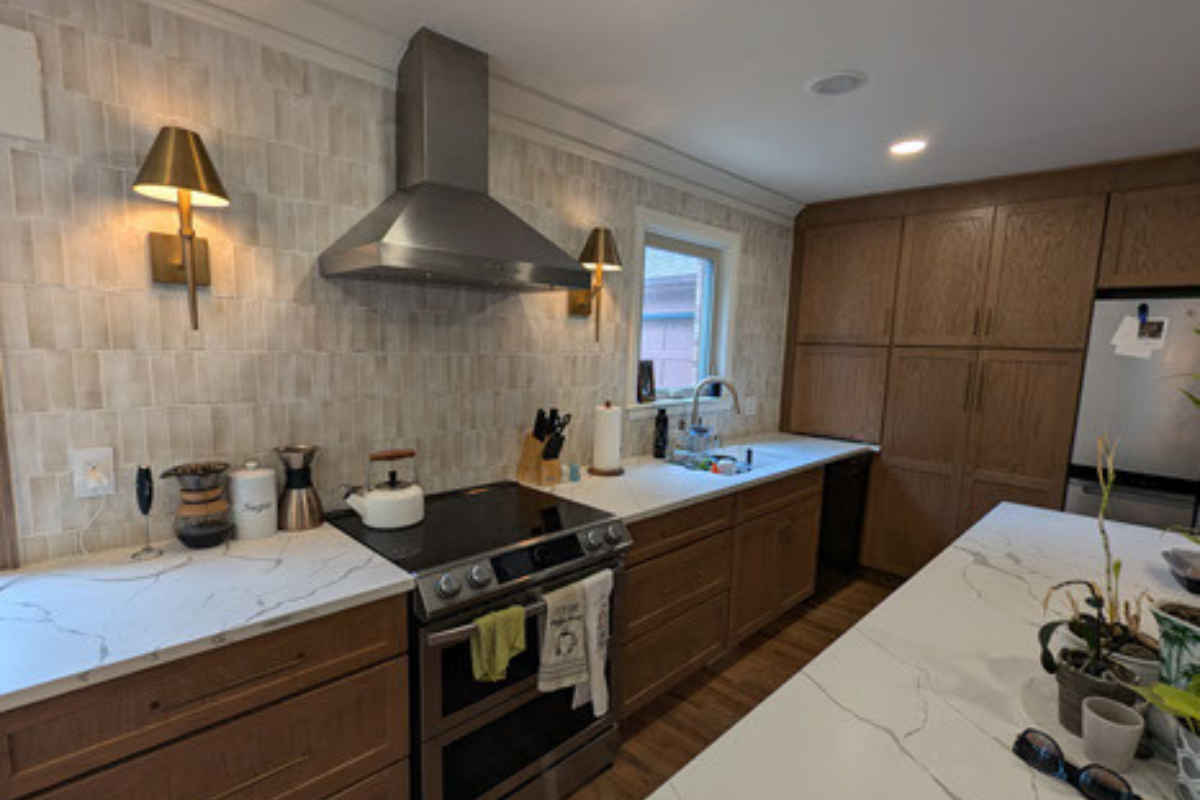 Oak shaker kitchen cabinet design with white quartz countertops and cream colored tile backsplash