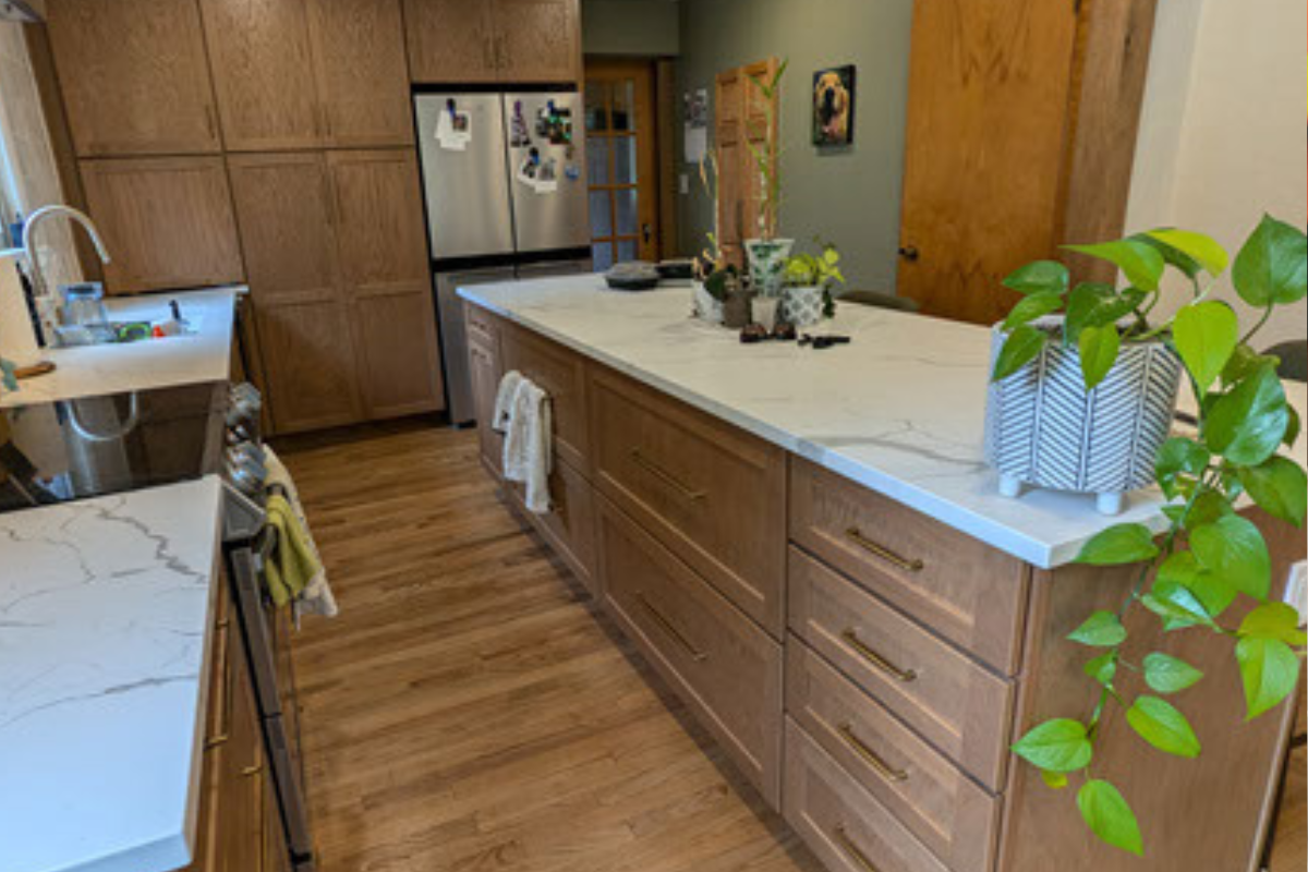 Oak shaker kitchen cabinet design with white quartz countertops and cream colored tile backsplash