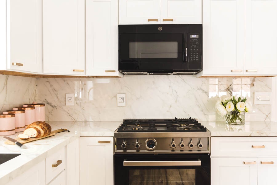 Over-the-Range Microwave and Vent Fan in a White Shaker Kitchen Cabinet.