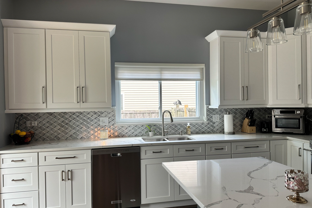 White shaker kitchen design with white quartz countertops and modern brushed nickel cabinet pulls