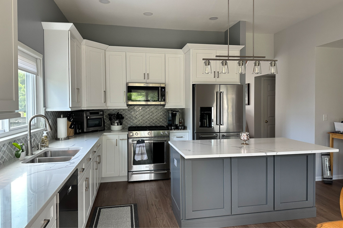 L-shaped white shaker kitchen with medium gray kitchen island and white quartz countertops