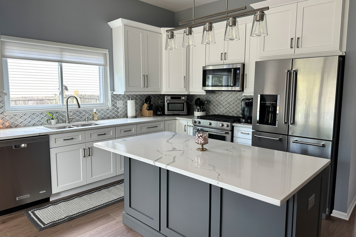 L-shaped white shaker kitchen with medium gray kitchen island and white quartz countertops