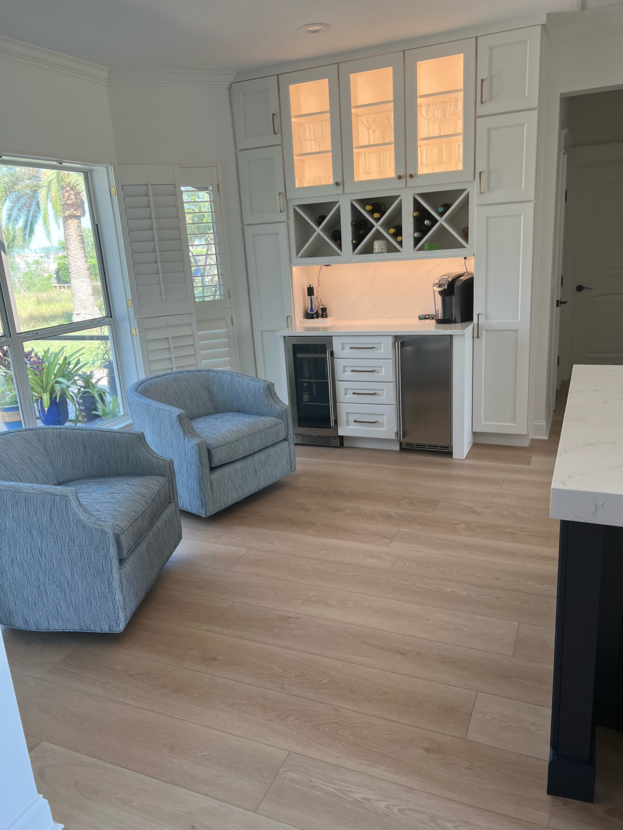 Decorative white shaker buffet kitchen cabinets with x-shaped wine racks, and glass wall cabinets above with lighting inside